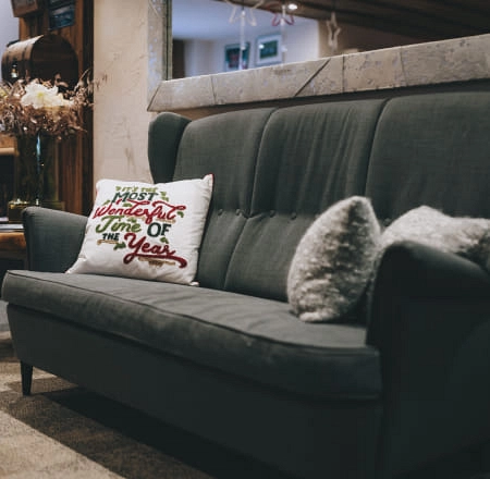 Grau Sofa mit dekorativem Kissen und einem Kissen in Form einer Eins.