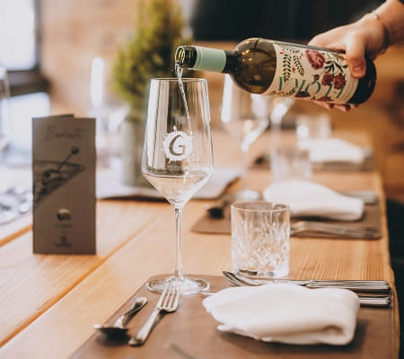 Tischgedeck im Restaurant Max Moritz mit Weinglas und Weinflasche