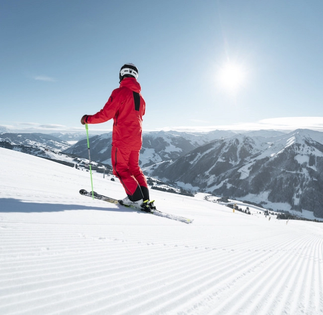 Skifahrer in roter Skijacke auf Piste in Saalbach-Hinterglemm-Leogang-Fieberbrunn